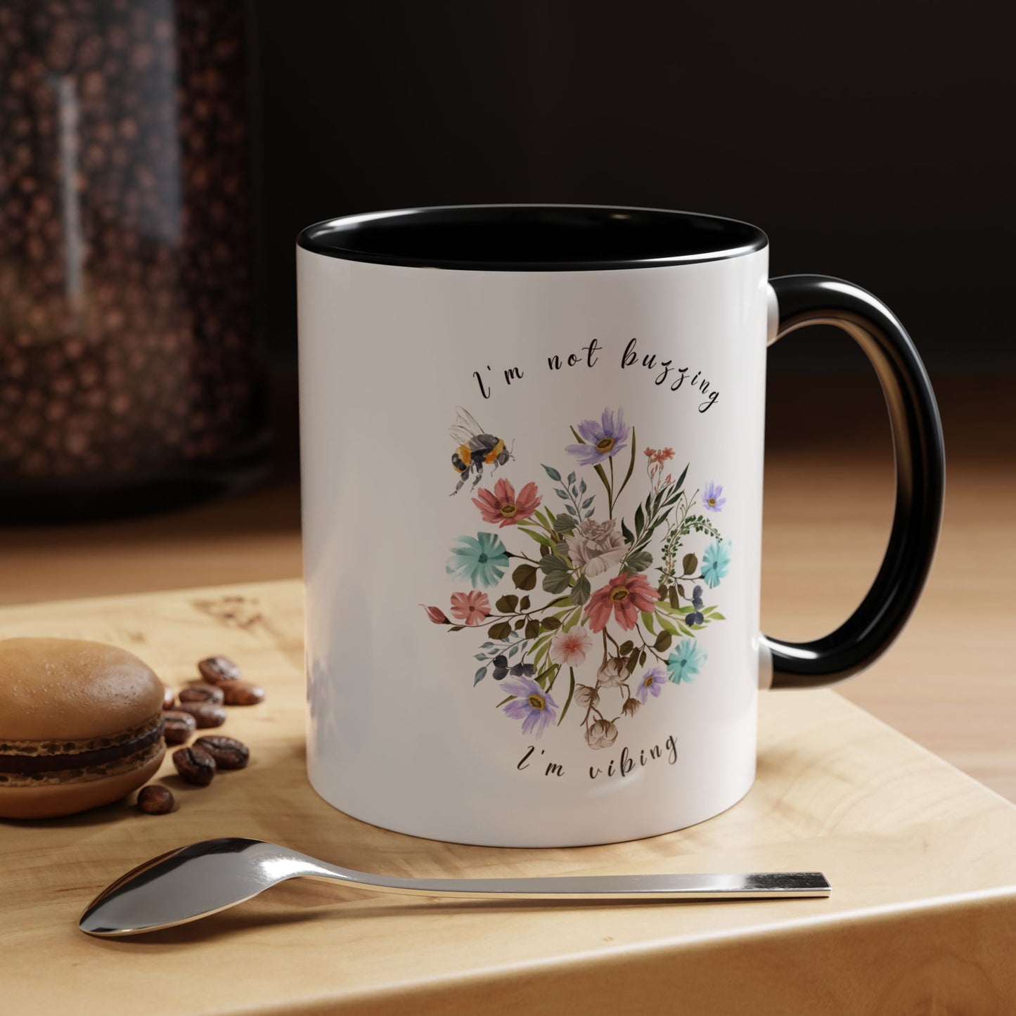 "I'm Not Buzzing, I'm Vibing" Bee & Wildflower Accent Coffee Mug, showcasing the charming bee and wildflower design on a white ceramic mug. Available in 11oz and 15oz sizes.