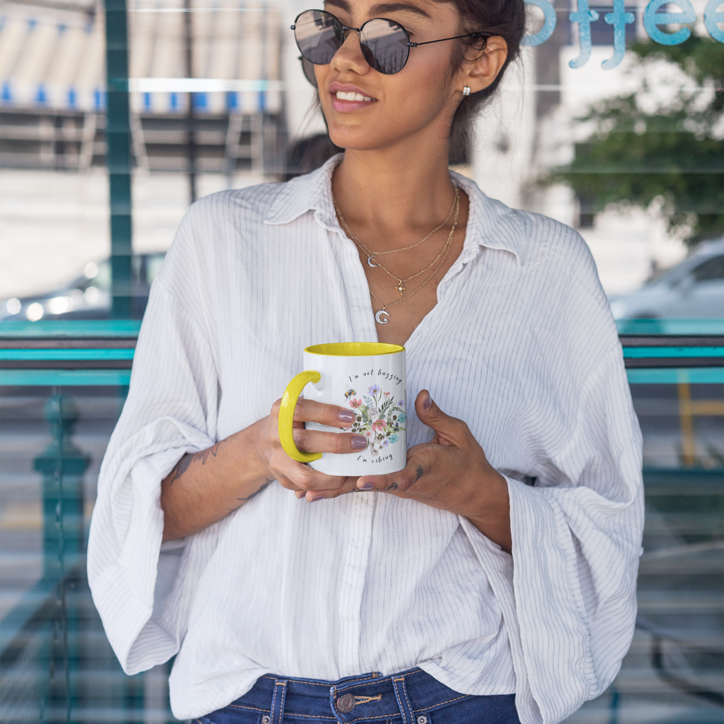 Lifestyle shot of the "I'm Not Buzzing, I'm Vibing" Bee Mug filled with coffee, demonstrating the comfortable C-shaped handle and its perfect size for enjoying a morning beverage.