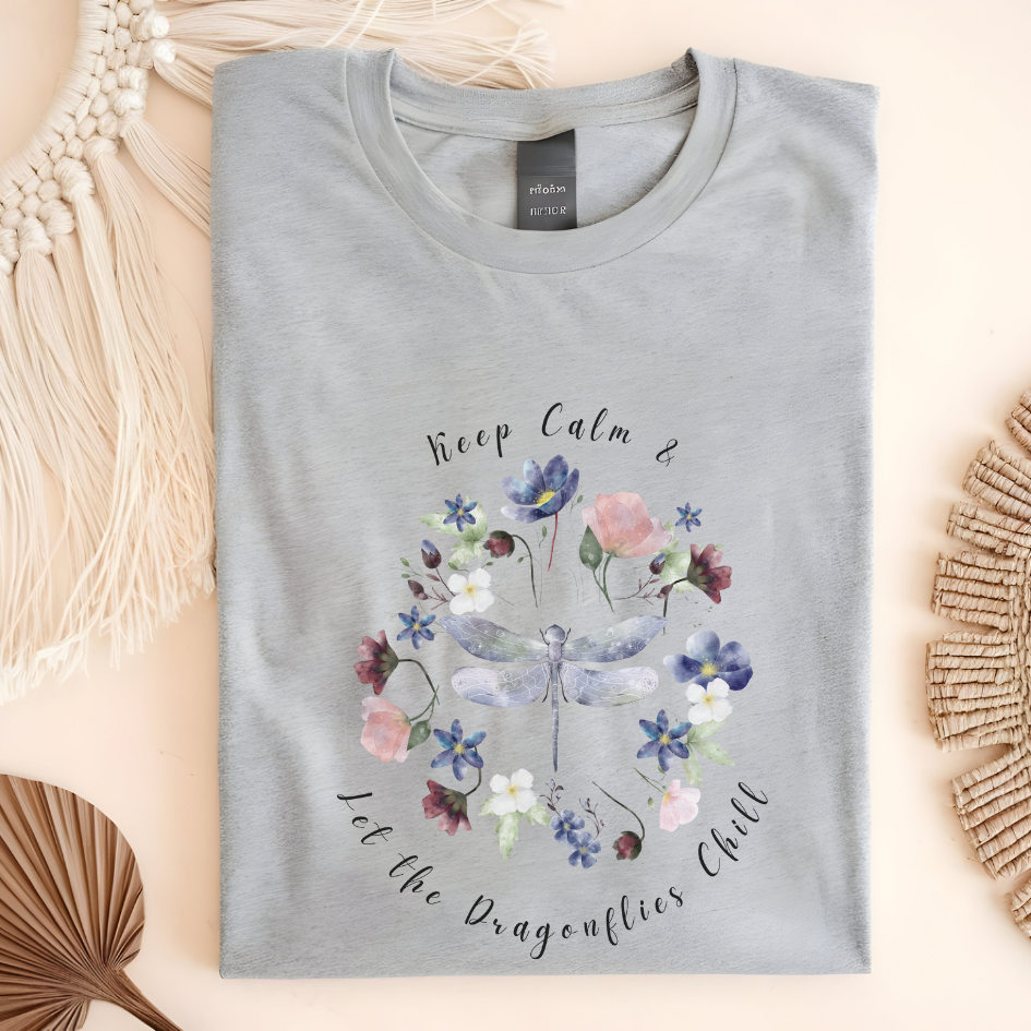 Flat lay of the "Chill Spring! Keep Calm & Let the Dragonflies Chill" T-Shirt, highlighting the soft, 100% ring-spun cotton fabric, classic crew neck, and the adorable dragonfly and floral wreath design. Color Sport Grey