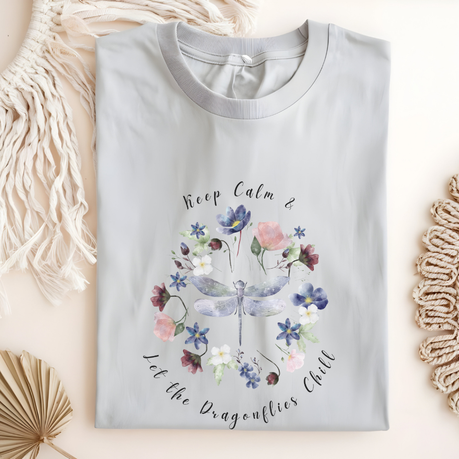 Flat lay of the "Chill Spring! Keep Calm & Let the Dragonflies Chill" T-Shirt, highlighting the soft, 100% ring-spun cotton fabric, classic crew neck, and the adorable dragonfly and floral wreath design. Color Ice grey