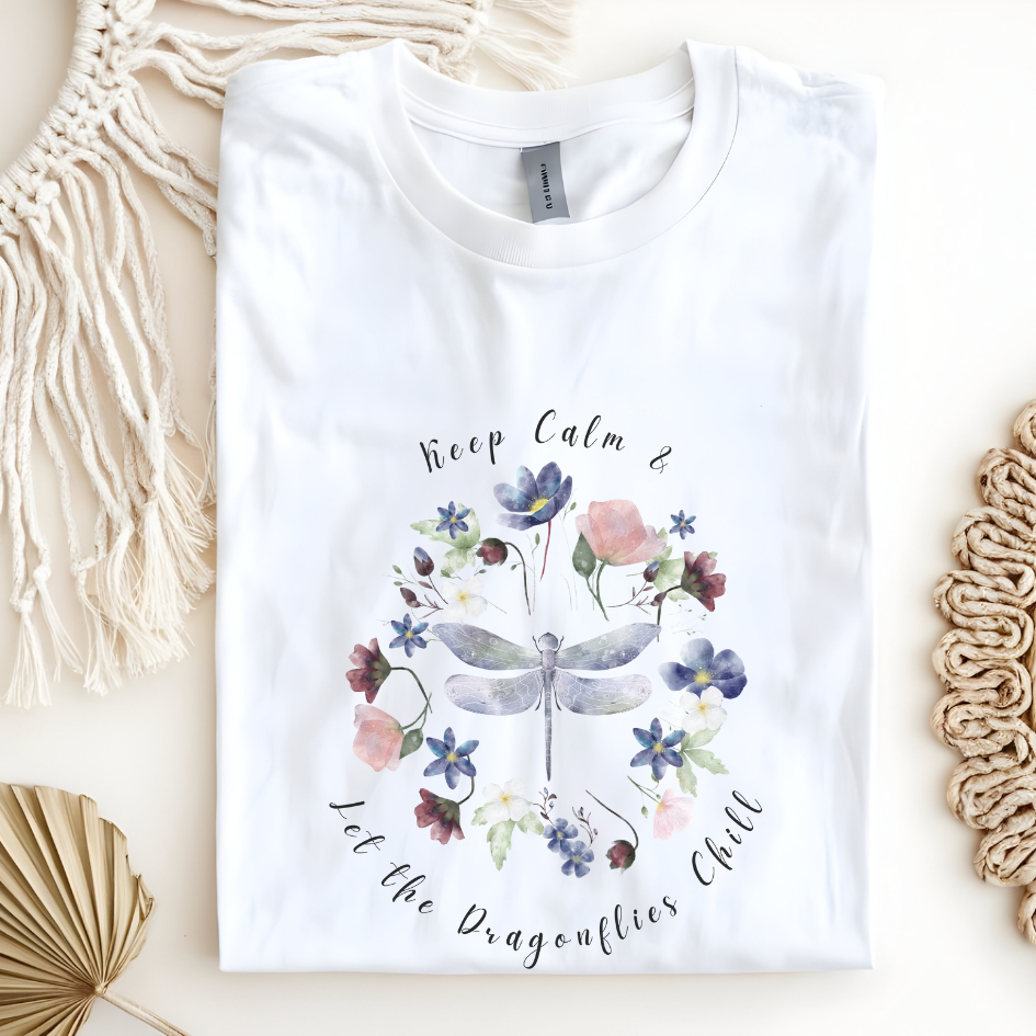 Flat lay of the "Chill Spring! Keep Calm & Let the Dragonflies Chill" T-Shirt, highlighting the soft, 100% ring-spun cotton fabric, classic crew neck, and the adorable dragonfly and floral wreath design. Color White