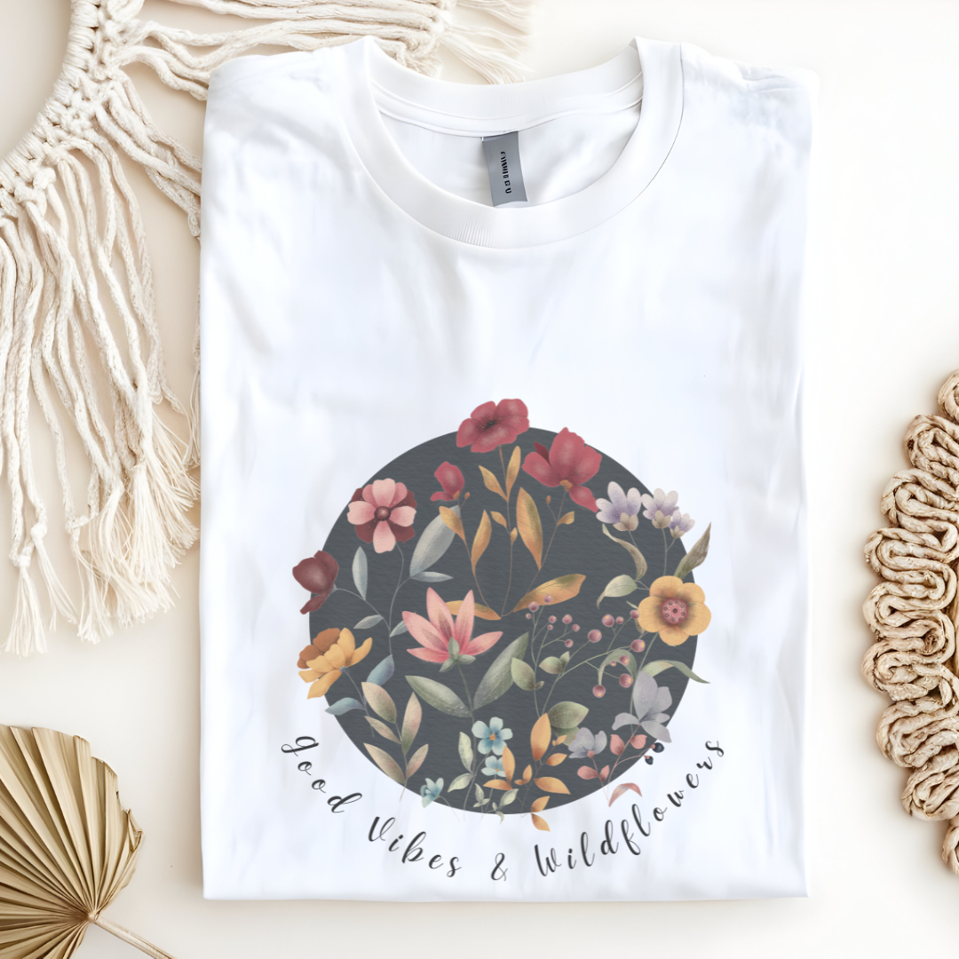 Flat lay of the "Hello Spring: Good Vibes & Wildflowers" Tee, highlighting the soft, 100% US cotton fabric, classic crew neck, and the beautiful botanical floral design.
