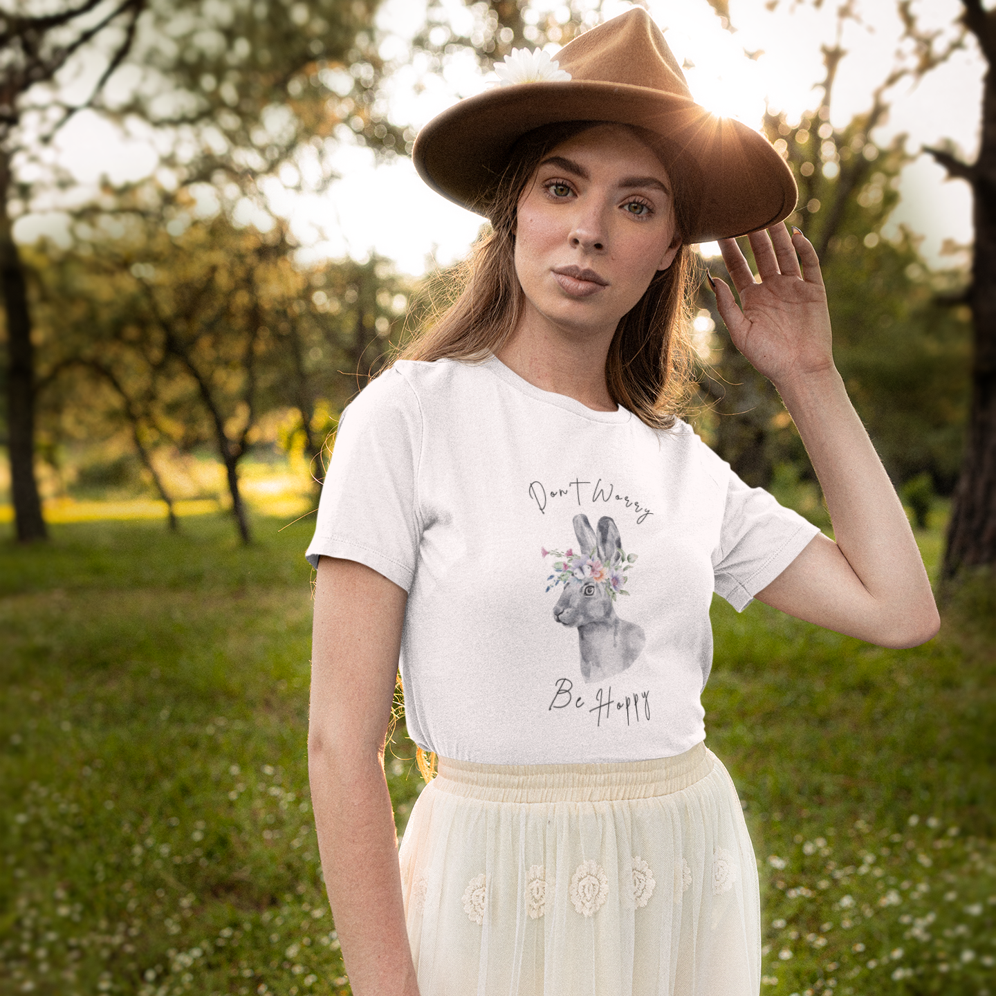 Lifestyle shot of a person wearing the "Don't Worry, Be Hoppy!" T-Shirt while relaxing in a blooming garden.