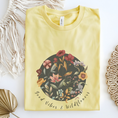 Flat lay of the "Hello Spring: Good Vibes & Wildflowers" Tee, highlighting the soft, 100% US cotton fabric, classic crew neck, and the beautiful botanical floral design. Color Cornsilk