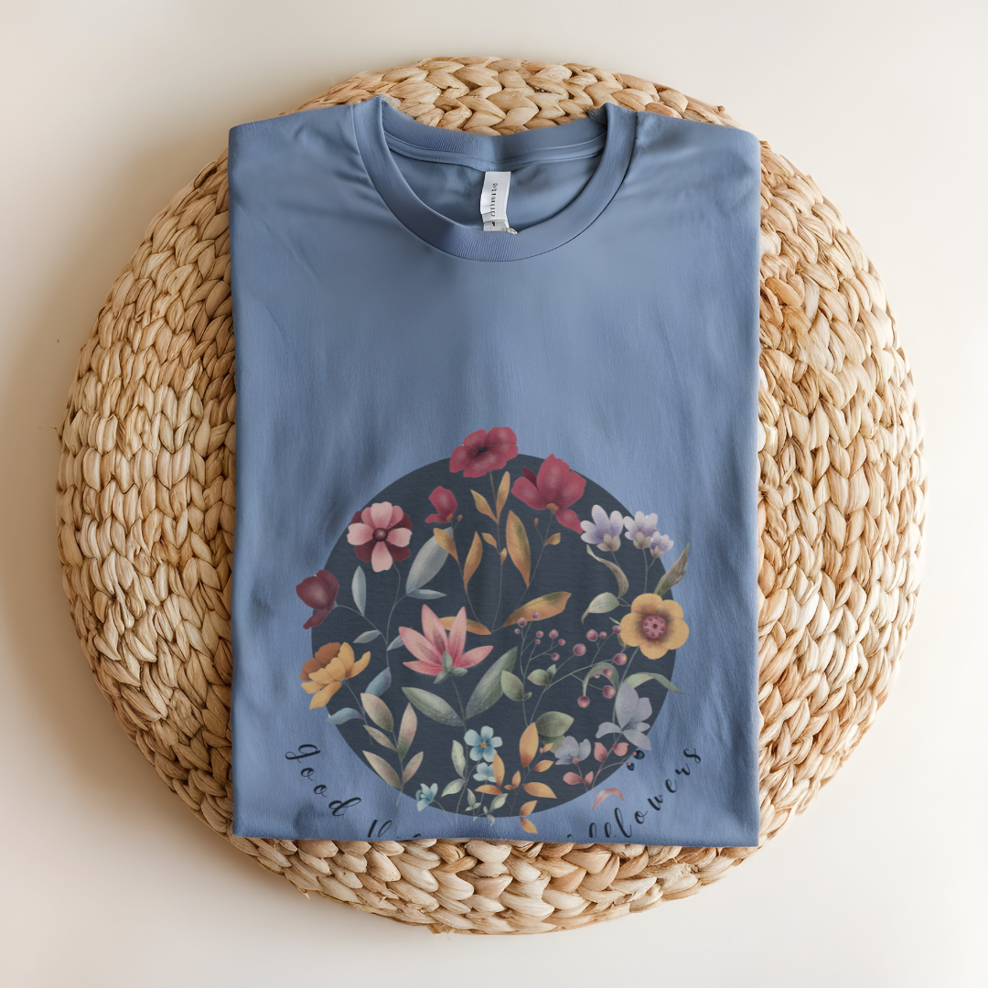 Flat lay of the "Hello Spring: Good Vibes & Wildflowers" Tee, highlighting the soft, 100% US cotton fabric, classic crew neck, and the beautiful botanical floral design. Color Heather Indigo
