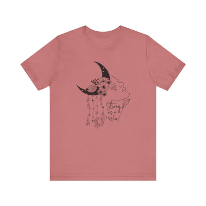 Flat lay of the "Strong as a Mother" T-Shirt, highlighting the soft Airlume cotton fabric and classic crew neckline. Color Mauve The graphic is clearly visible, showing the woman's profile, crescent moon, flowers, and charms in detail.