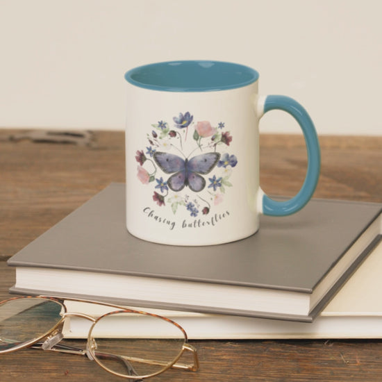 Lifestyle shot of the Butterfly & Wildflower Accent Coffee Mug filled with coffee, showing the comfortable C-shaped handle and the perfect size for enjoying your favorite beverage.