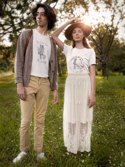 Lifestyle shot of a couple  wearing the "Hoppin' into Spring" T-Shirt strolling through a blooming park. The charming watercolor rabbit and floral wreath design adds a touch of springtime elegance.